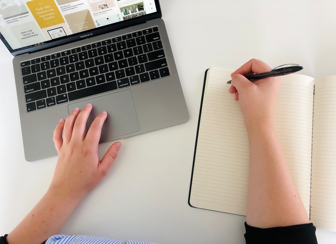 Journalist working on news story with laptop and notepad