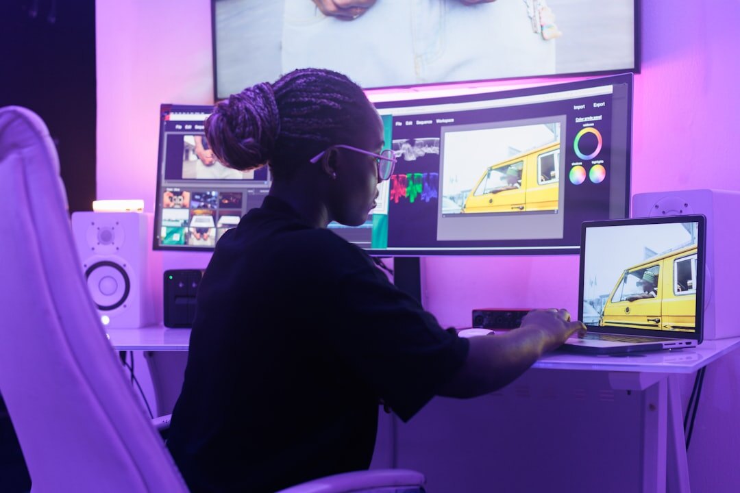 Person editing video on computer with multiple screens